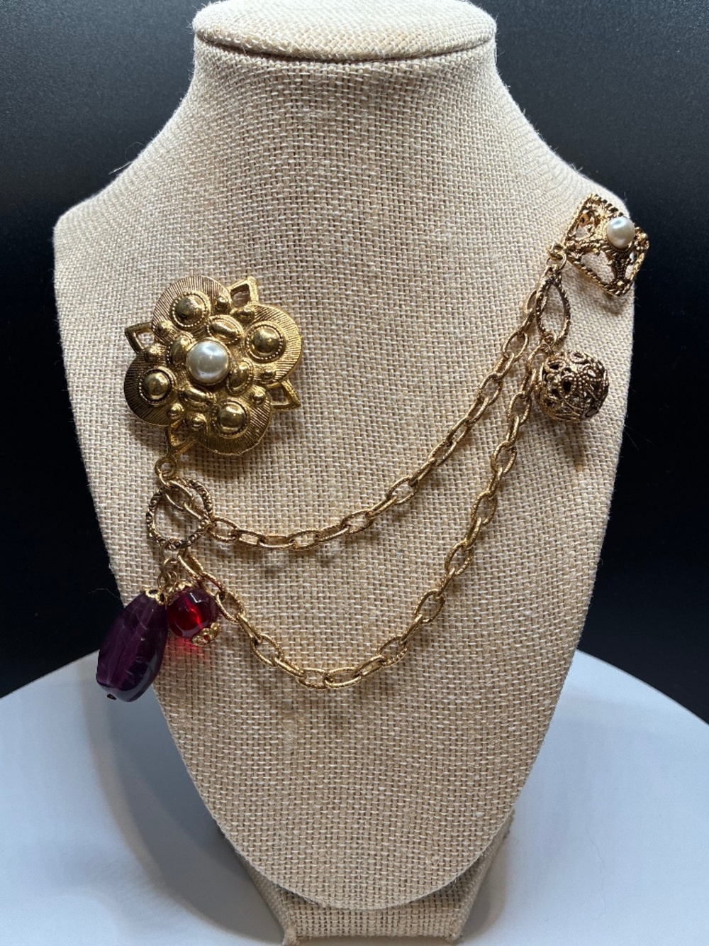 Vintage 1980s gold tone brooch with a double pin red and purple stones